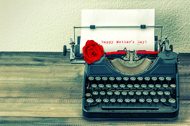 istock Vintage typewriter with white page and red rose flower 475930092
