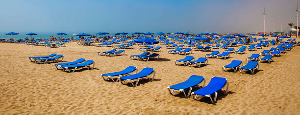istock Sun loungers on sunny beach for tourists sunbathing. 475930170