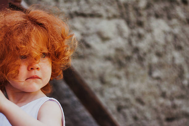 Close up of a little scared redhead girl.