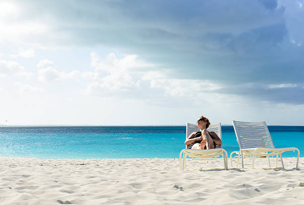 Calm Day at the Beach A female lounging on a beach chair at a white beach in the Caribbean. Grace Bay stock pictures, royalty-free photos & images