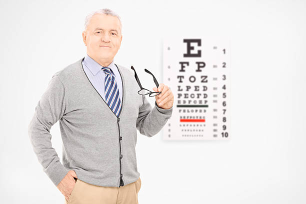 istock Mature man holding glasses in front of an eye chart 475941249