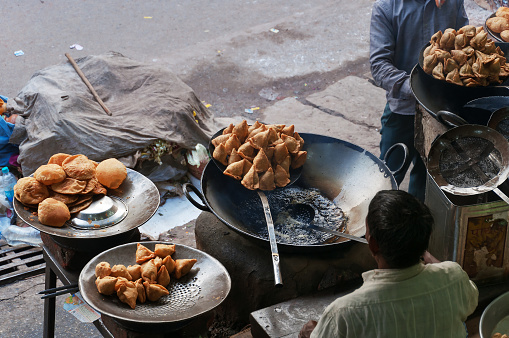 Varanasi, India  - December 23, 2014:  Indian street food in the street market. Varanasi. Uttar Pradesh. India. Indian man sells food
