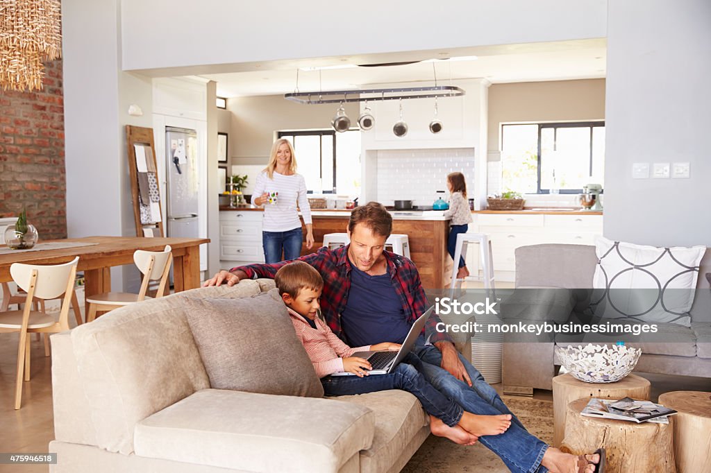 Family spending time together at home Family spending time together at home. Father and Son looking at laptop Family Stock Photo