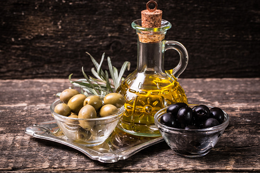 Olive oil and olives on wooden table