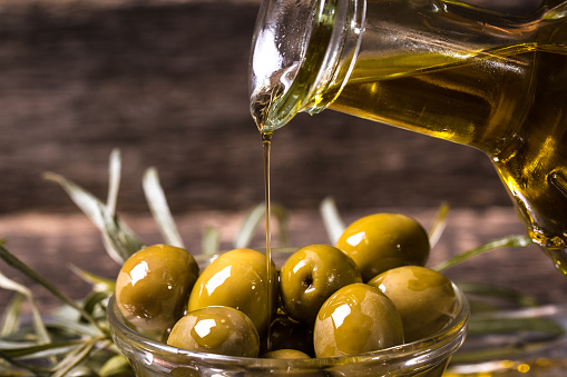 Olive oil and olives on wooden table