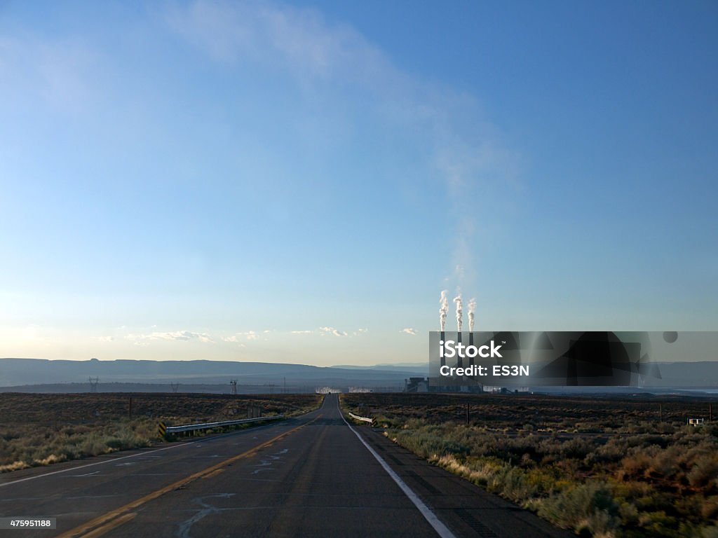 Power plant in the desert Sunset on the Arizona red desert road, Navajo power plant in background with some rises from the chimneys 2015 Stock Photo