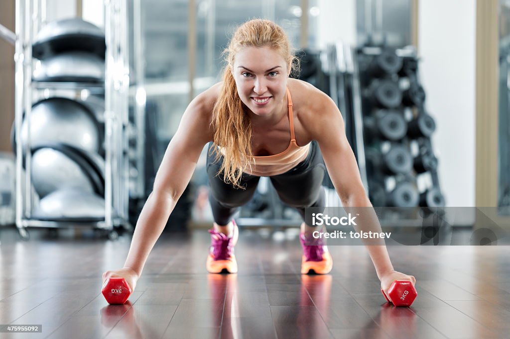 Woman workouts in the gym Woman push-ups on the floor at the gym 2015 Stock Photo