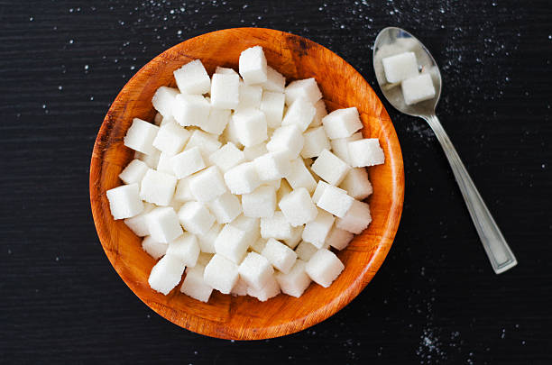 istock White sugar cubes in wooden bowl spoon on dark table 475958244