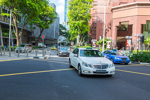 Singapore, Singapore - May 11, 2015: A luxury taxi in traffic on the upmarket luxury shopping street of Orchard Road in Singapore