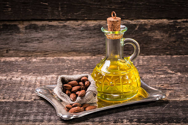 istock Almond nuts and oil on wooden table 475961744
