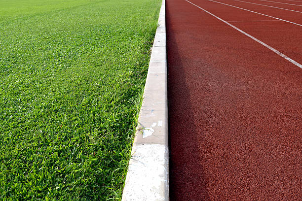 white line zwischen grünen gras-feld und track laufsteg - soccer soccer field grass american football stock-fotos und bilder