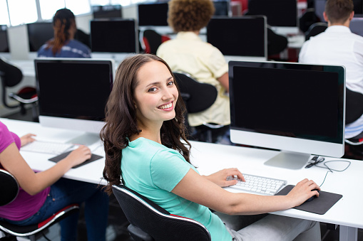 Female student smiling at camera in computer class