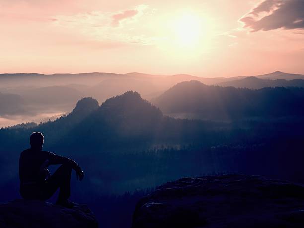 istock Tourist in black wind jacket sit on rocky mountain 475964948