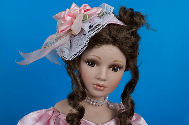 istock pretty doll face wearing hat over blue background 475966282