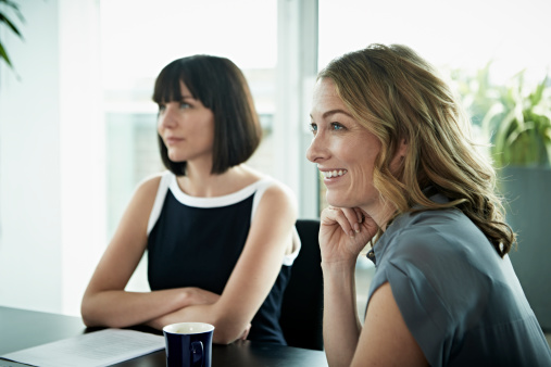 Smiling businesswoman listening to presentation in a meeting