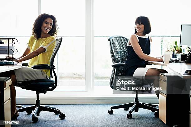 Female Coworkers Laughing Stock Photo - Download Image Now - Office Chair, Office, Desk