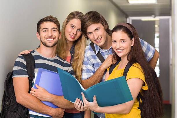 istock Students holding folders at college corridor 475971714