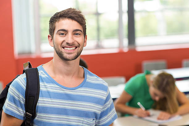 istock Happy male student standing in the classroom 475976468