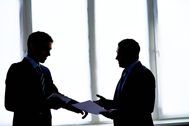 Back lit dialogue Back lit image of two men having business talk talking two people business talk business stock pictures, royalty-free photos & images