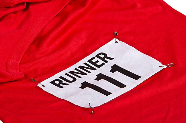 Race number on running shirt Race number on bib attached to the front of red running shirt baby bib stock pictures, royalty-free photos & images