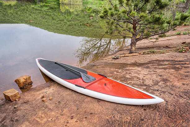 istock stand up paddleborad on a rocky lake shore 475981932