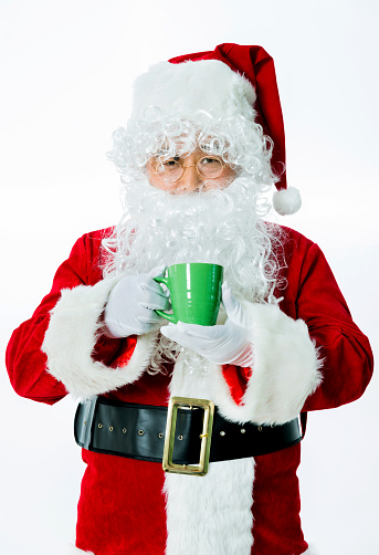 Santa claus holding a cup of tea isolated on white background.