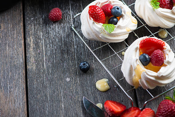 istock Decorating homemade pavlova meringue with berries fruit 475986850