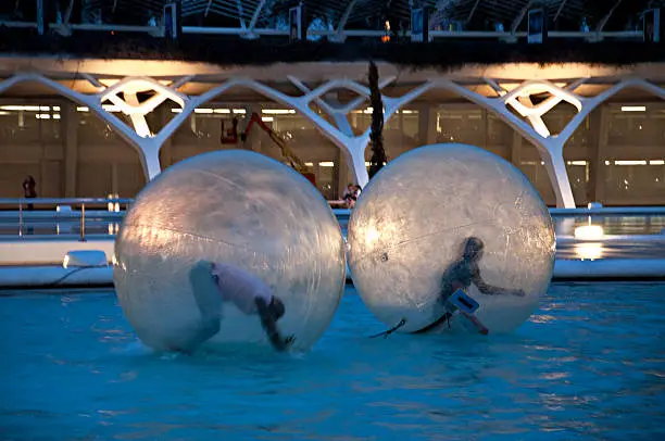 Photo of Children have fun in huge zorbing ball on water