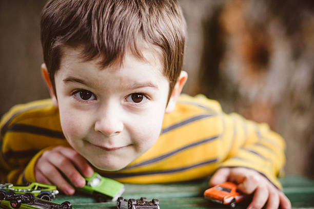 istock Boy plays with toy cars outside 475991214