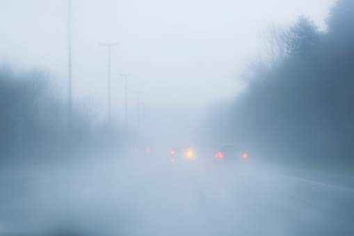 cars on a road in a foggy and rainy day