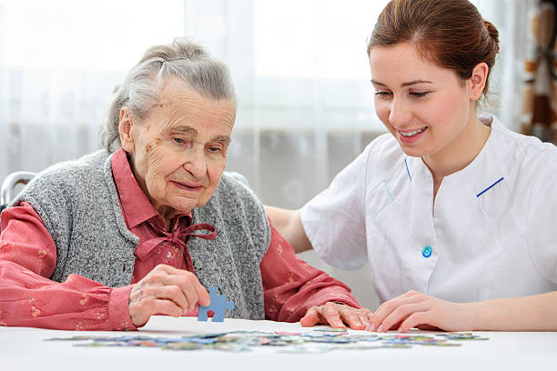 femme âgée avec son nourricier - senior adult leisure games playing care photos et images de collection