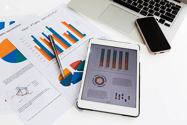 istock Financial charts on the table with tablet phone and pen 475992737