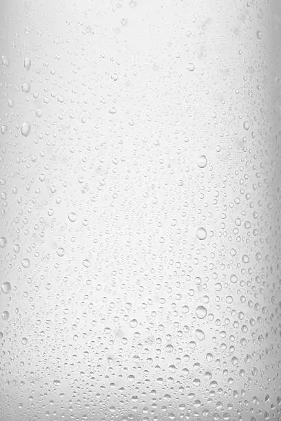 Close up. Ice cold  glass  Fresh water with ice cubes,  background.  Covered with water drops  condensation.