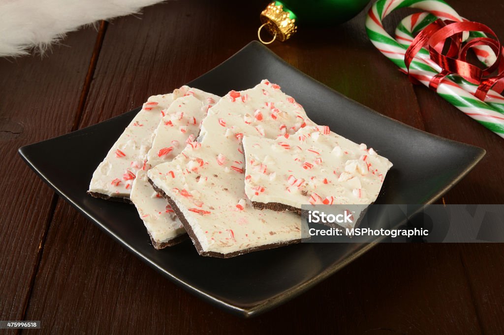 Peppermint Bark A plate of peppermint bark with candy canes and Christmas decorations Plant Bark Stock Photo