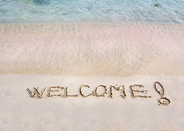 istock Welcome message written on white sand, sea waves in background 475996745