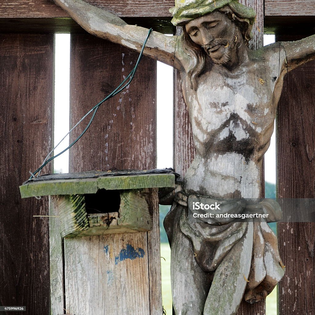 Sheltered home A wooden nesting box, a tit box beneath a depiction of the crucifixion of Jesus Christ. What could go wrong with the offspring in such a sheltered home? Picture taken near Vagen, Bavaria. 2015 Stock Photo