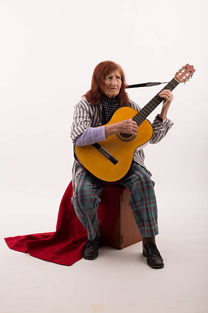 istock Funny elderly lady playing acoustic guitar 475997756