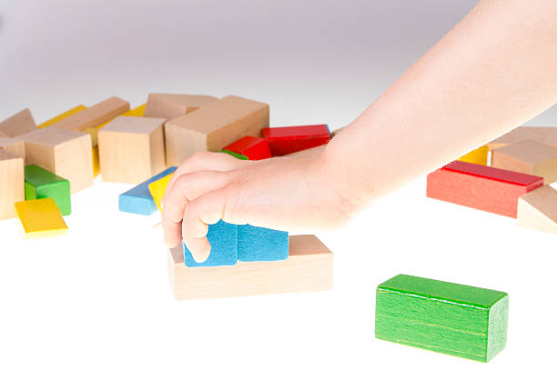 istock Child's hand and building blocks 475997844