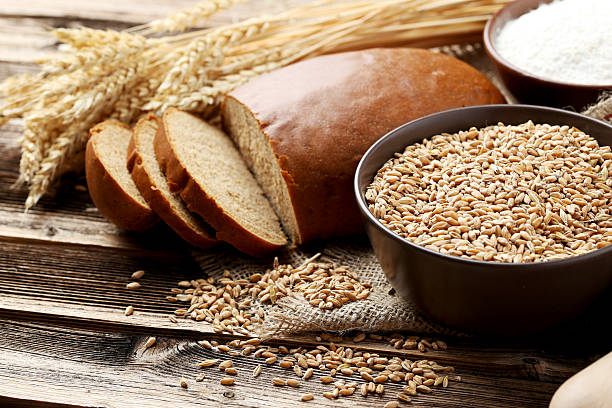 istock fresh bread and wheat on brown wooden background 475998078