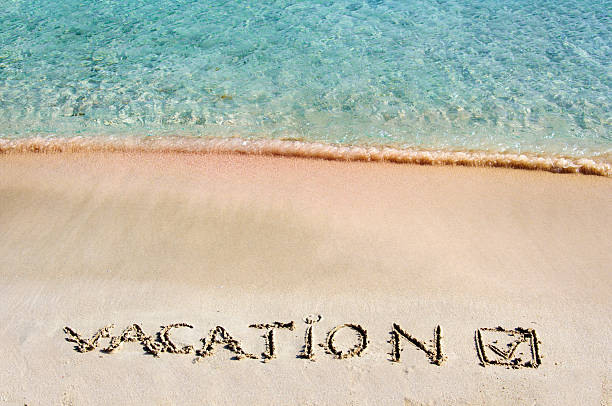 istock Vacation and checked mark written on sand 475998999
