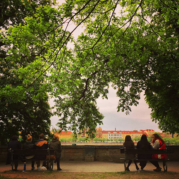 Prague, Czech Republic  - May 3, 2015: People enjoying Prague view sitting in park