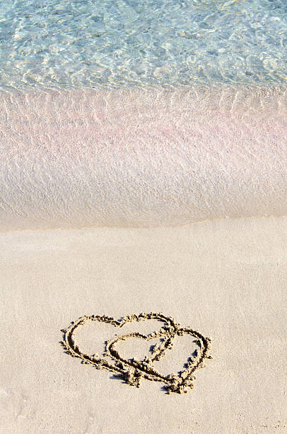istock Two hearts drawn in the sand on a beautiful beach 476007213