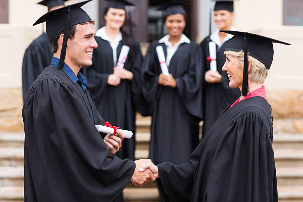 istock young graduate shaking hand with professor 476007817