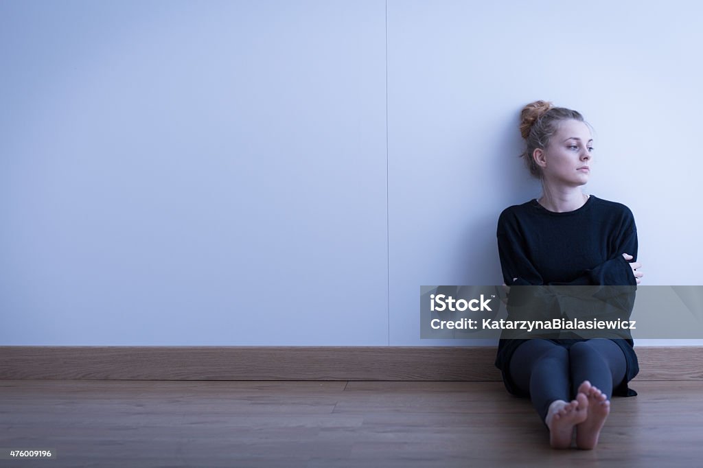 Lonely thoughtful girl Lonely thoughtful girl sitting on the floor 2015 Stock Photo