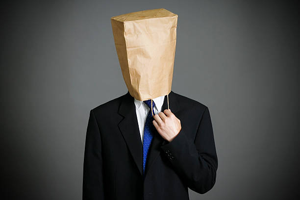 hombre de negocios con una bolsa de papel en la cabeza - embarrassment men business guilt fotografías e imágenes de stock