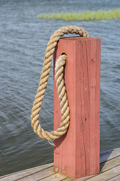 istock Red wooden boat bollard and rope 476010532