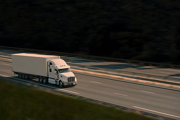 white semi truck on road with sunlight stock photo