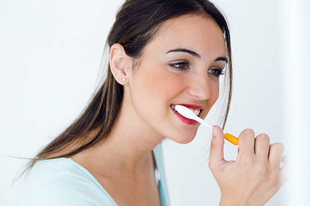 istock Pretty young woman brushing her teeth. 476013060