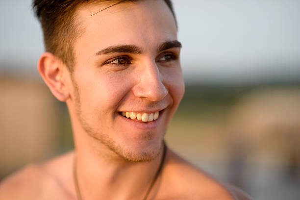 Studio portrait of an attractive 18 year old man in a black T-shirt on a black background