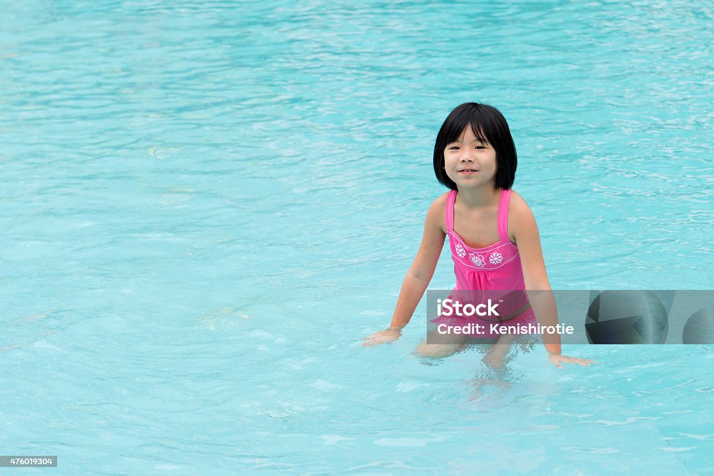 Little Asian girl in swimming pool Portrait of little Asian girl in swimming pool 2015 Stock Photo